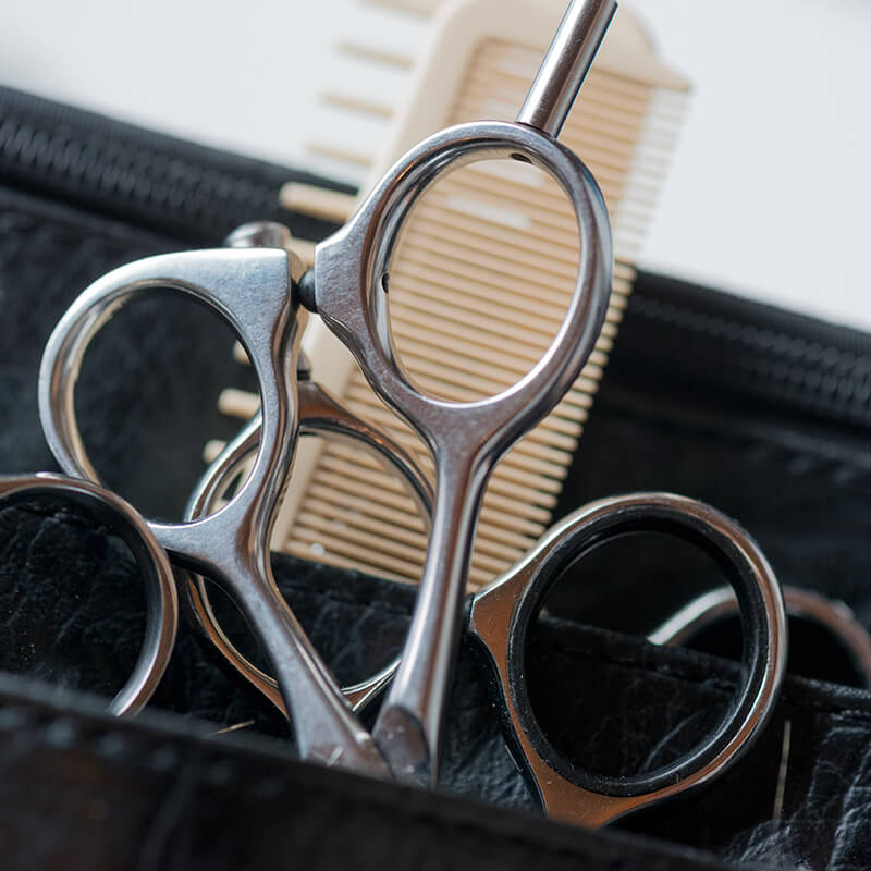 Man med kortklippt frisyr framför Aderans Hair Center logon